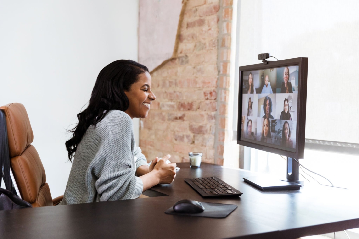 Cheerful businesswoman talks with colleagues during video call